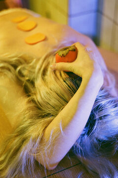 White haired girl bitting a fruit