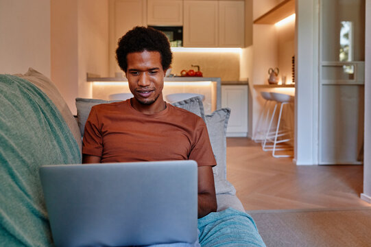 Smiling man working on a laptop at home