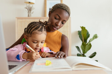 Black mother and daughter doing homework