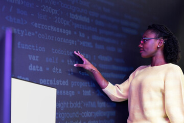 Woman analysing binary code on virtual screen