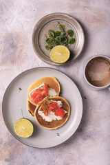 Breakfast with freshly baked pancakes on a plate and a cup of coffee