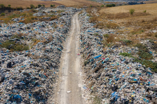 road to a garbage heap full on plastic pollution