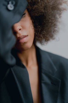 Woman With Afro Wearing Suit In Front Of White Background