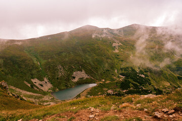 Lake Brebeneskul in the clouds, a view of the lake from the Montenegrin ridge, high-altitude ecologically clean lake in the Carpathians, a nature reserve.