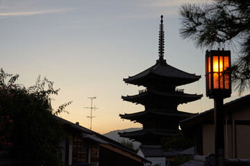 Traditional oriental pagoda in garden against sunset sky
