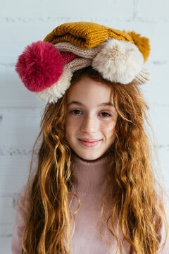 Girl with stack of hats on head