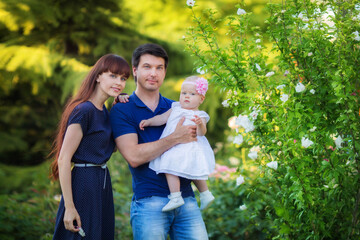 Father, mother and child daughter spending time outdoor on a summer day.