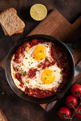 Israel traditional food shakshouka with micro greens in a cast-iron pan