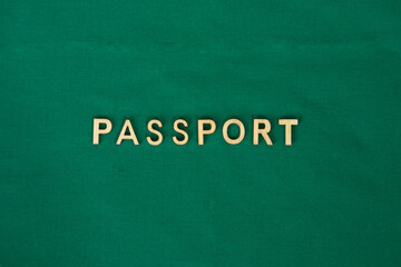 Fototapeta na wymiar COVID vaccine passport wooden alphabet letters on a green fabric. Green Passport.