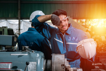 man engineering wear uniform take off the helmet hand up wipe sweat tired from work. industrial...