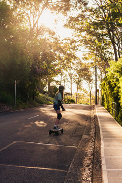 teen skating on the road on an electric skateboard