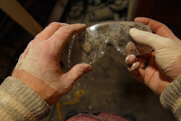 Crop artisan cleaning goggles from dust