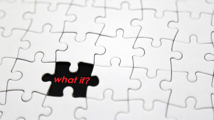 Word 'what if?' in missing piece of white jigsaw puzzle. Concept for presentation. Selective focus.