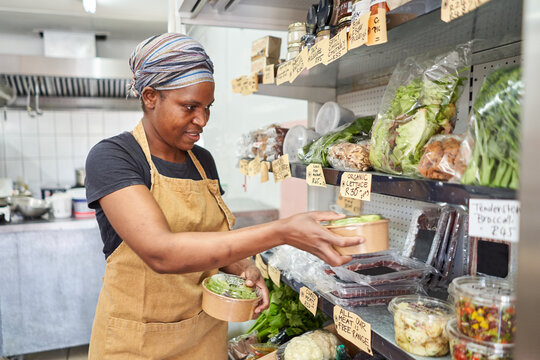 Deli owner packing produce in store