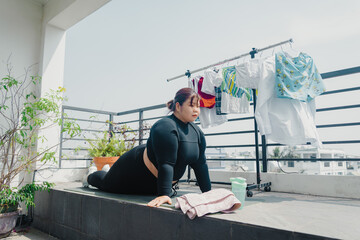 Health, fitness and sports concept. Plus size young asian woman doing exercise on mat in balcony, going to loose extra pounds at home, become strong and fit, training endurance.