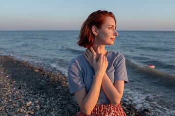 Woman enjoys sunset at the seaside