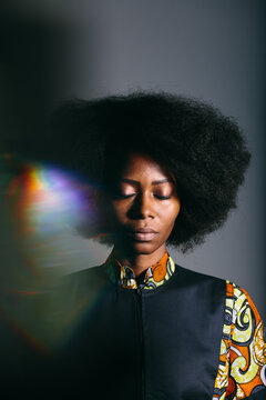 Black woman with curly hair with eyes closed