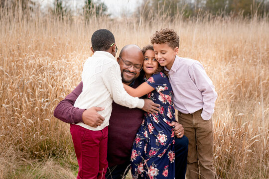 Girl makes funny face while hugging her family