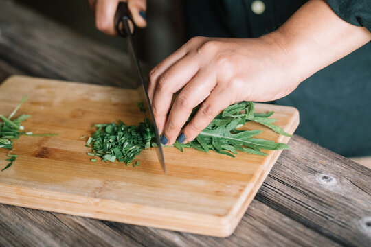 Anonymous Woman Cutting Fresh Mint Sage And Marjoram For Handmade Dolmadakia