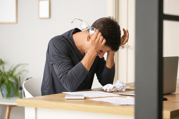 Portrait of stressed young man at home