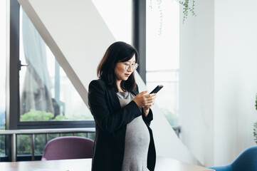 Asian business pregnant woman in office