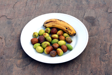 some fresh sweet fruits put in a white plate isolated on stone background