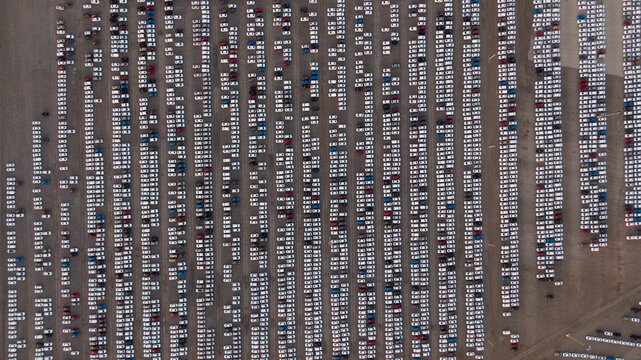 Large car parking in front of a car factory - grid filled with cars
