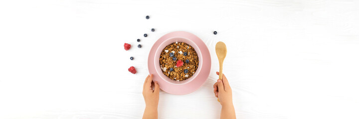 Child s hands holding spoon over table with healthy food.