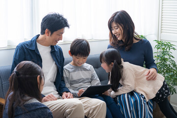 タブレットPCを見る日本人家族 © arc image gallery