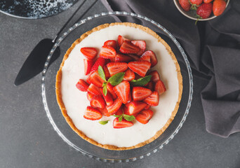 Tasty cheesecake with strawberry on dark background