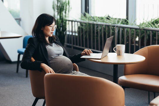 Asian business pregnant woman in office