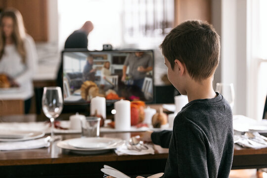 Thanksgiving: Boy Sets Table While Relatives On Monitor Do Same
