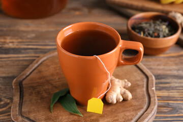 Obraz na płótnie Canvas Cup of aromatic black tea on wooden background