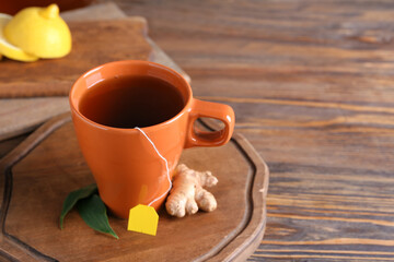 Cup of aromatic black tea on wooden background