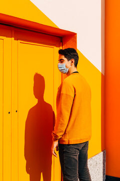 Man Standing In Front Of A Orange Entrance Door And Wall