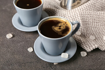 Cups of hot coffee on dark background