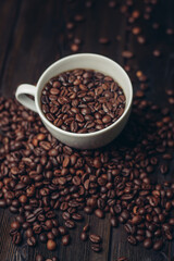 cup with coffee grains on a wooden table aromatic drink Arabica product