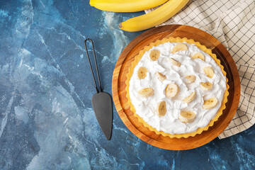 Dessert stand with tasty banana pie on color background