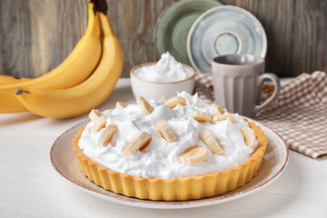 Plate with tasty banana pie on table