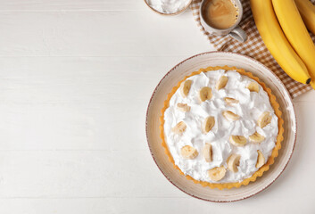 Plate with tasty banana pie on light background