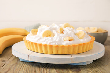 Board with tasty banana pie on table