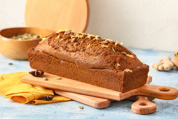 Boards with tasty gingerbread cake on color background