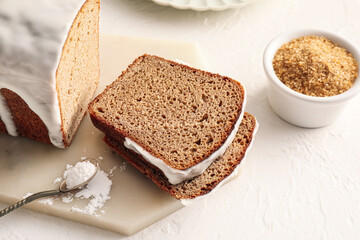 Board with tasty gingerbread cake on light background