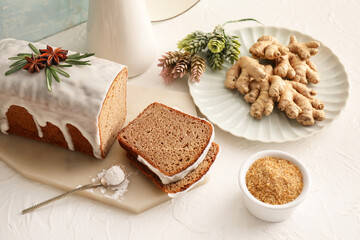 Board with tasty gingerbread cake on light background