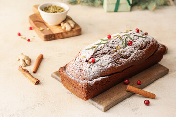 Board with tasty gingerbread cake on light background
