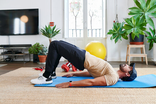 Fit man doing hip thrusts at home