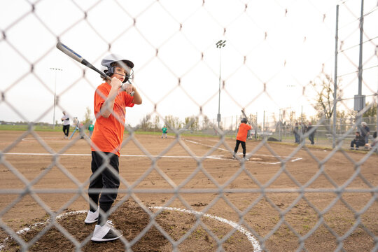 Boy with bat stands in warmup circle