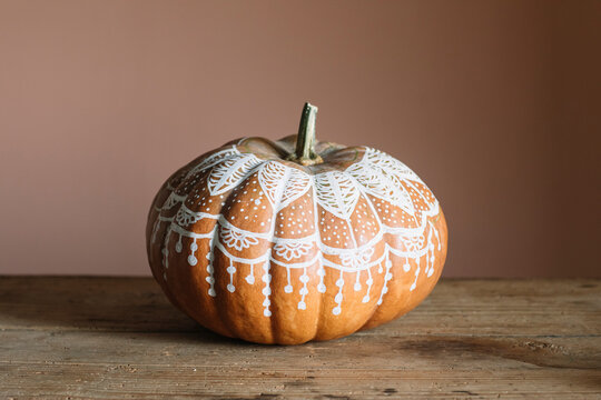 Decorated pumpkin on a wooden table