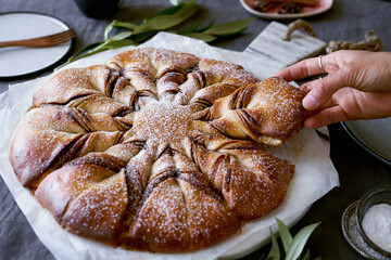Hand pulling bread apart at party
