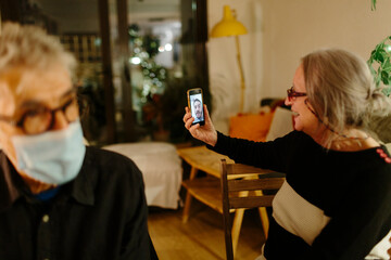 Woman video chatting with a family member at home at night